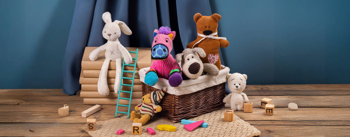 A collection of colorful stuffed animals including a bunny, zebra, dog, and teddy bears arranged with wooden blocks and a toy ladder