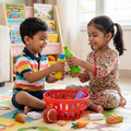 Indian boy rainbow striped polo Indian girl floral salwar kameez laughing exchanging toy grocery bottles red basket between them toy carrots tomato bread roll soap bar scattered animal print play mat