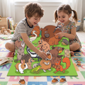 White boy grey striped tee White girl floral dress cross-legged colourful alphabet play mat large assembled green woodland animal puzzle between them boy placing acorn-shaped piece girl grinning loose acorn pieces linen bag wooden blocks
