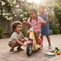 Girl in braids beaming with joy astride Retro Mini Moped on rose-covered garden paving while boy crouches to inspect front wheel and older boy laughs behind