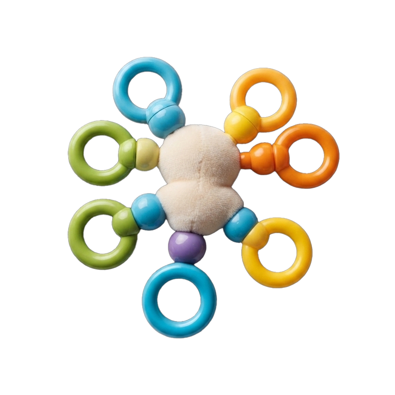 Rainbow Ring Activity Toy flat lay top-down symmetrical view white background soft white plush centre perfectly centred 6 coloured connector arms star symmetry teal top-left orange top-right orange right yellow bottom-right teal bottom-centre green bottom-left purple bottom bead all rings distinct